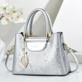 Bolso tote plateado con piel de serpiente, herrajes dorados y colgante de hoja en blanco - Plateado