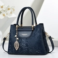 Bolso azul marino con textura de serpiente, detalles dorados y colgante de perla y hoja - Azul