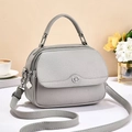 Grey litchi grain leather crossbody bag with top handle and silver clover pendant details - Gray