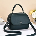Close-up of dark green crossbody bag with lychee grain texture and silver hardware - Dark Green