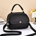Dettaglio borsa in pelle martellata nera con cerniere doppie e ciondolo quadrifoglio - Nero