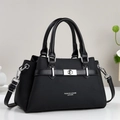Classic black fabric handbag with silver metal lock and leather straps shown on white desk - Black