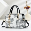 Elegant paisley patterned beige shoulder bag with black handles and gold pendant detail - Black