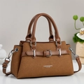 Detailed view of caramel brown handbag featuring leather strap and metal buckle hardware - Khaki/Earth Yellow