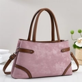 Detalle del bolso rosa de ante con correas de cuero marrón y remaches de metal plateado - Rosa