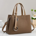 Gros plan sur la texture tressée et l'anneau métallique du sac fourre-tout brun - Khaki