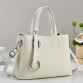 Detail showing creamy white leather tote bag with subtle V-shaped woven texture and silver ring - Off-white