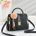 Elegant black minimalist tote bag with gold hardware and plush pompom charm detail - Black