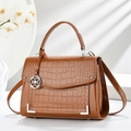 Glossy brown crocodile pattern crossbody bag with round silver pendant and top handle - Khaki/Earth Yellow