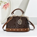 Brown snake-embossed satchel bag with gold rivets and heart pendant on white background - Brown