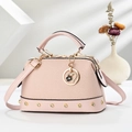 Detail of light pink patchwork pillow bag with woven texture and gold heart pendant charm - Pink