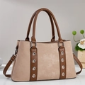 Dettaglio della borsa retrò in beige e marrone con accenti di occhielli metallici - Cachi