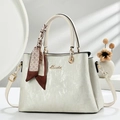 Elegante beige Handtasche mit Perlmuttstreifen, Seidenschal und goldfarbenen Metallteilen - Cremeweiß
