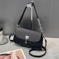 Detail of black underarm bag featuring textured flap and silver chain strap on a T-stand - Black