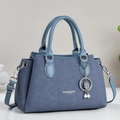 Navy blue textured leather handbag with light blue handles and a clover charm - Blue