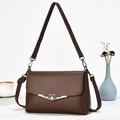 Elegante borsa a tracolla in pelle marrone con chiusura vintage a cuore su sfondo bianco - caffè