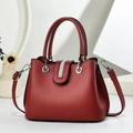 Close-up of deep red leather handbag with vertical rhinestone bar and silver ring detail - Wine Red