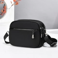 Dettaglio di borsa a tracolla nera con multi-zip e quattro scomparti funzionali - Nero (Hardware color canna di fucile)