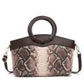 Detail of elegant snake pattern texture with leather round handle and gold hardware - Coffee