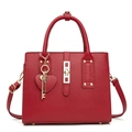Détail de sac à main rouge montrant le fermoir doré et le pendentif en forme de cœur - Rouge
