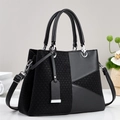 Detail of black tote bag featuring textured weaving and silver-tone metal hardware - Black