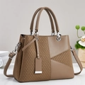 Detail of trendy brown textured patchwork handbag with sleek metal ring and slim strap - Khaki