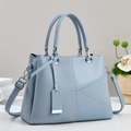 Detail of light blue crossbody bag featuring woven texture and geometric stitching - Blue