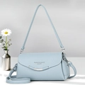 Detail of light blue crossbody bag with lychee grain texture and silver hardware logo - Blue