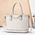 Detalle de bolso tote beige en cuero premium con herrajes dorados y correa ajustable - Blanco