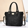Detalle de bolso tote negro mate con herrajes dorados y correa de hombro ajustable - Negro