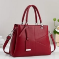 Détails du sac à main en cuir grainé bordeaux avec boucles argentées et double poignée - Rouge
