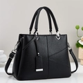 Détail d'un sac à main noir en cuir litchi avec ferrures argentées et bandoulière réglable - Noir