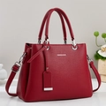 Macro shot of dark red tote bag with lychee texture and silver logo lettering - Red