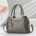Taupe quilted tote bag with metal handle and floral texture on a minimalist background - Gray