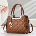 Detail of brown quilted handbag with clover stitching and starfish shell charms - Earthy Yellow
