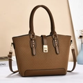 Brown woven texture handbag with sleek leather trim and gold twist lock in lifestyle setting - Brown