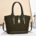 Detailed shot of dark green knit tote bag with golden clasp and leather handles - Green