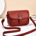 Brick red pebble leather crossbody bag with top handle and gold-tone buckle closure - Red