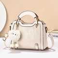 Détail du sac à main blanc crème avec textures verticales et charmant porte-clés - Blanc