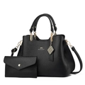 Close-up of black litchi leather handbag set with gold hardware and logo detail - Black