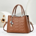 Detailed close-up of brown quilted leather handbag with shell and pearl charms decoration - Khaki/Earth Yellow