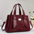 Elegant deep red tote bag with vertical textures and gold hardware on a minimalist stage - Red