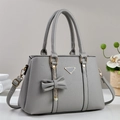 Elegante bolso de mano gris con textura litchi, lazo colgante y detalles dorados - Gris