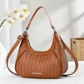 Detail of a brown woven hobo bag with leather straps and silver metal CB DESIGN logo - Khaki/Earth Yellow