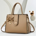 Detail of brown litchi pattern leather handbag with bow charm and gold side zippers - Dark Khaki