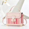 Detail of pink leather woven crossbody bag featuring a golden T-shaped metal lock and strap - Pink