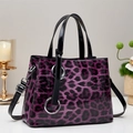 Detailed macro view of purple leopard print handbag with glossy finish and silver rings - Purple