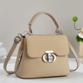 Detail der beigen gewebten Handtasche mit silbernem Drehverschluss und Leder-Schultergurt - Khaki