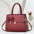 Chic burgundy satchel with lychee texture, bow pendant, and elegant pearl accents - Wine Red