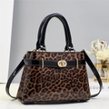 Detail of leopard print handbag with glossy black handles and elegant golden hardware - Brown
